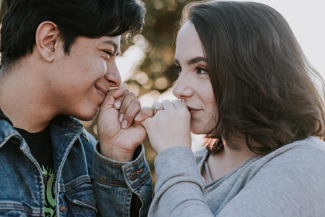 Couple kissing hands showcasing ring photographer in Albuquerque