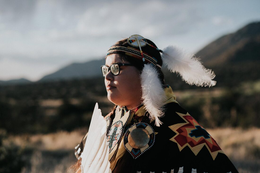 Indigenous girl staring into the distance wearing traditional outfit 